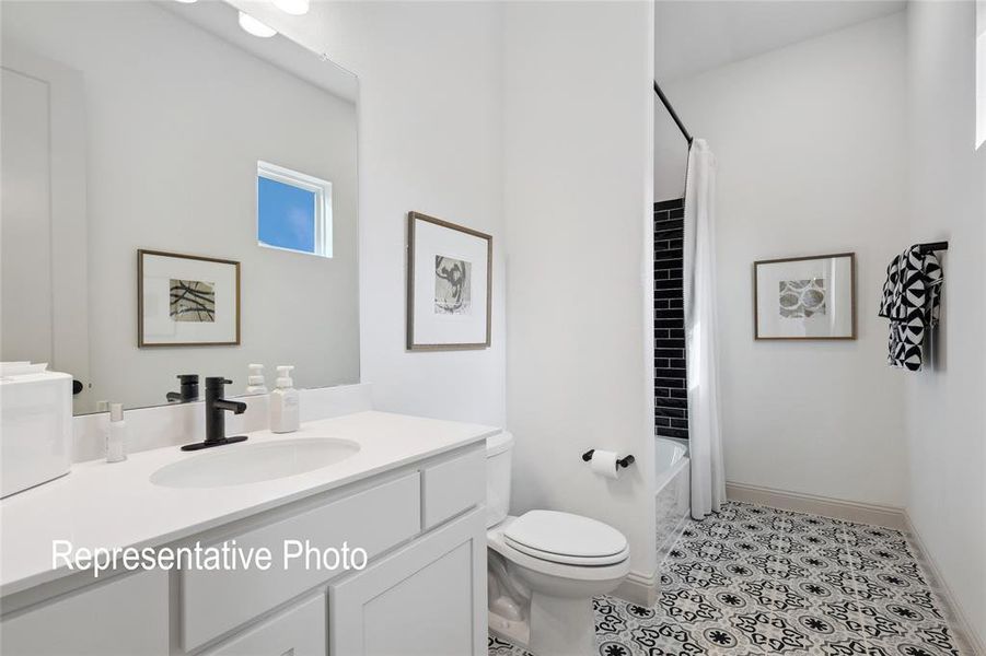 White vanity with an integrated sink and matte black faucet, framed mirror, built-in tub with black subway tile surround, patterned floor tile, and a rectangular window