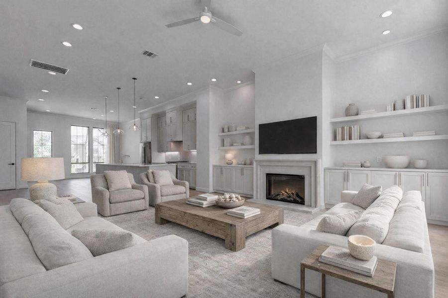 Expansive open-concept second-floor living area showcasing the heart of this contemporary 3-bedroom, 3.5-bath Memorial townhome. A sleek gas fireplace is framed by custom built-in shelving and cabinetry, creating a stylish focal point. The living area connects seamlessly to the chef’s kitchen with an oversized island, Bosch appliances, and Dekton countertops, creating an ideal setting for everyday living and entertaining. This photo has been virtually staged for visual reference.