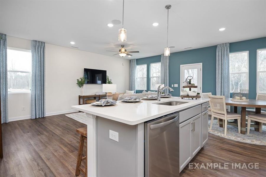 Kitchen with sink, a center island with sink, dishwasher, dark hardwood / wood-style floors, and plenty of natural light