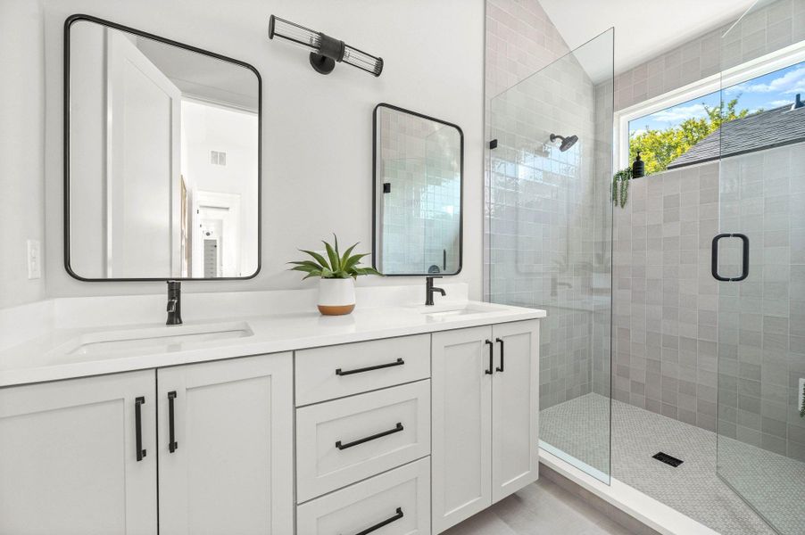 Bathroom featuring a shower stall and double vanity Bathroom featuring a shower stall and double vanity