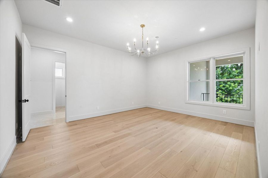 The second-floor primary suite offers a private retreat with wood floors, generous natural light, and a view of the balcony. The second-floor primary suite offers a private retreat with wood floors, generous natural light, and a view of the balcony.