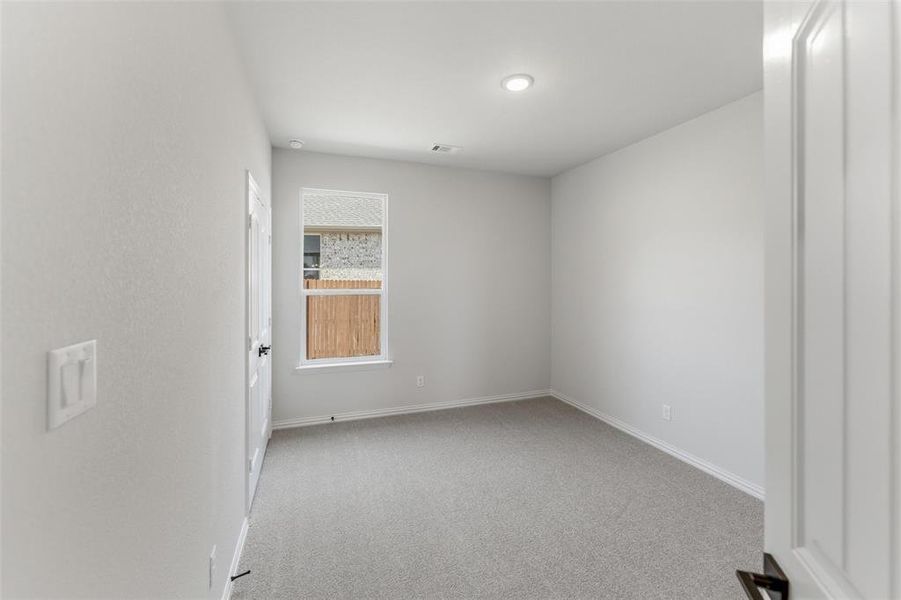 Empty room featuring light carpet and baseboards
