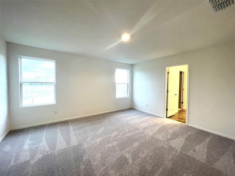 Empty room featuring carpet, visible vents, and baseboards