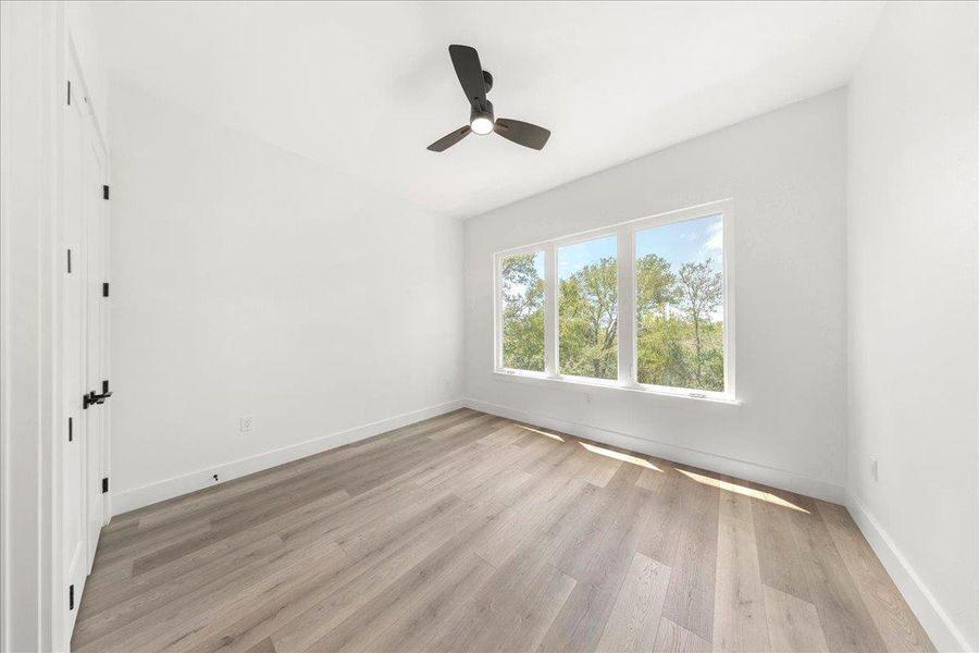 Spare room featuring light wood-style flooring and a ceiling fan Spare room featuring light wood-style flooring and a ceiling fan