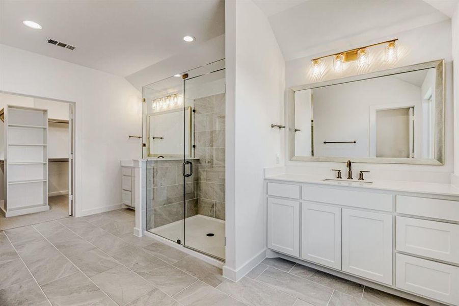 Bathroom with vanity, a walk in closet, a shower stall, and recessed lighting