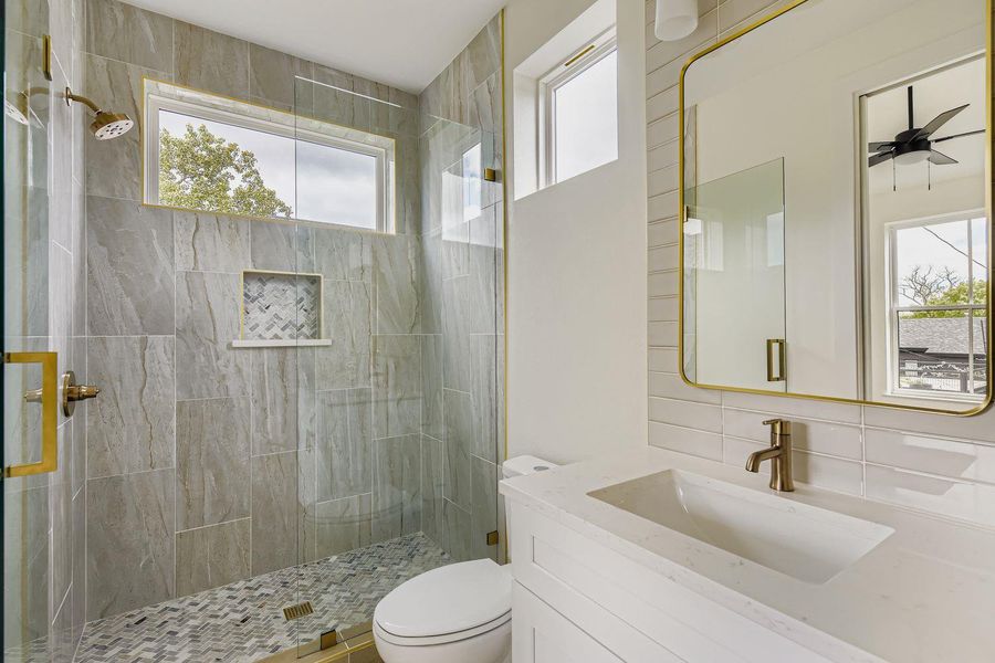 Full bath featuring vanity, a shower stall, and backsplash Full bath featuring vanity, a shower stall, and backsplash