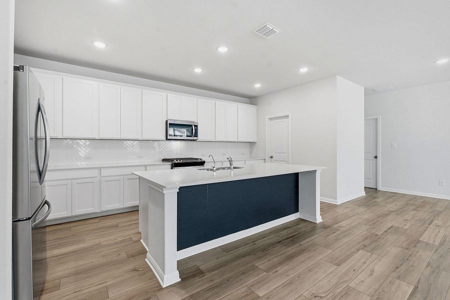Bright, open-concept kitchen with a spacious island, sleek stainless steel appliances, and stylish tile backsplash. Bright, open-concept kitchen with a spacious island, sleek stainless steel appliances, and stylish tile backsplash.