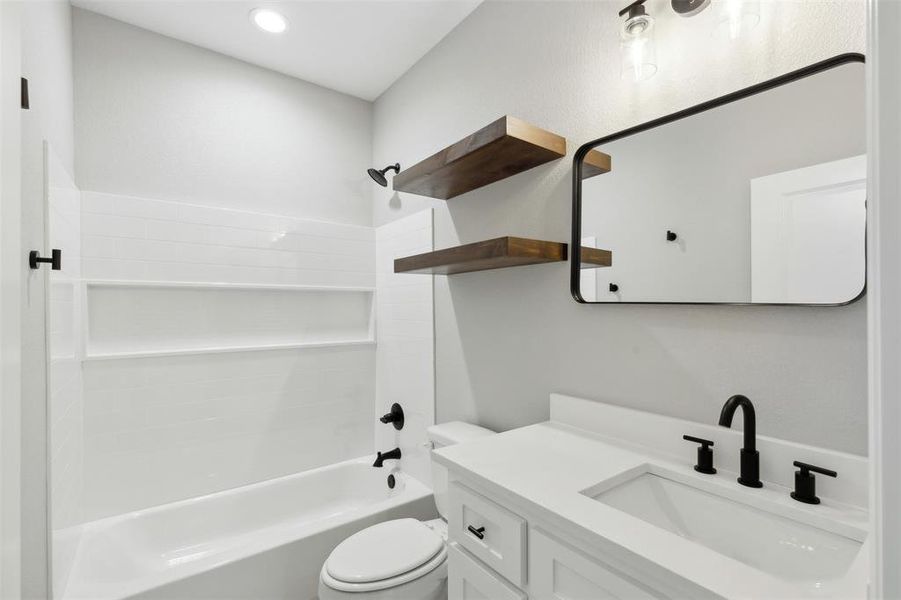 Full bathroom featuring washtub / shower combination, toilet, and vanity