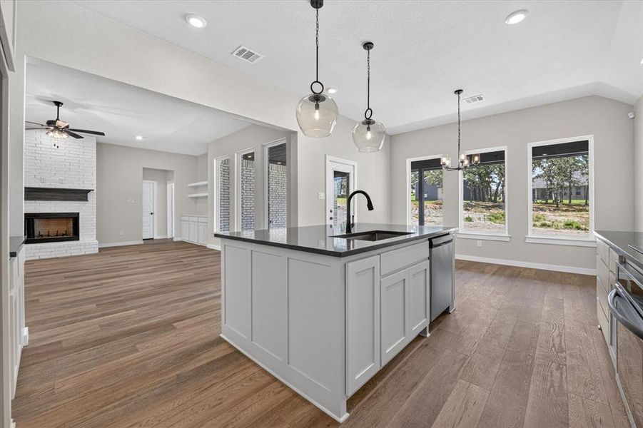 Kitchen island with integrated sink, black countertop, and pendant lighting Kitchen island with integrated sink, black countertop, and pendant lighting