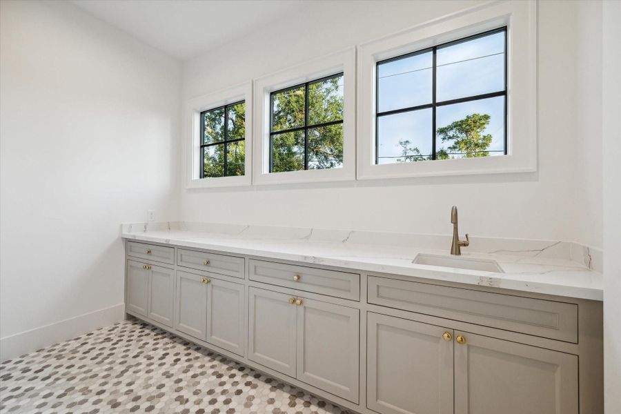 Central Laundry Room complete with sink, lots of storage, folding counter and hanging area for clothes to dry*Picture is of a recently constructed home by the builder.  1519 Candlelight will be similar in quality, but these pictures are not meant to be an exact representation of the new home. Specs of home may change at sole discretion of the seller.