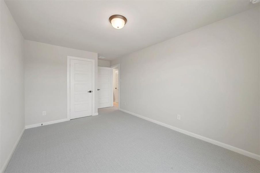 Interior room featuring light gray wall paint, gray carpet flooring, white trim, and a flush mount ceiling light fixture