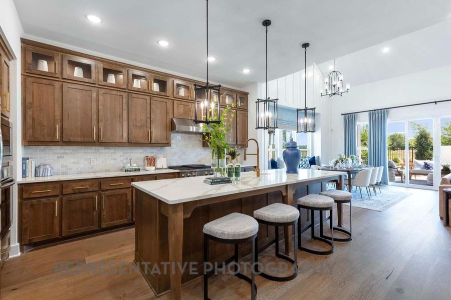 Kitchen with a breakfast bar, backsplash, dark wood-type flooring, a kitchen island with sink, and recessed lighting