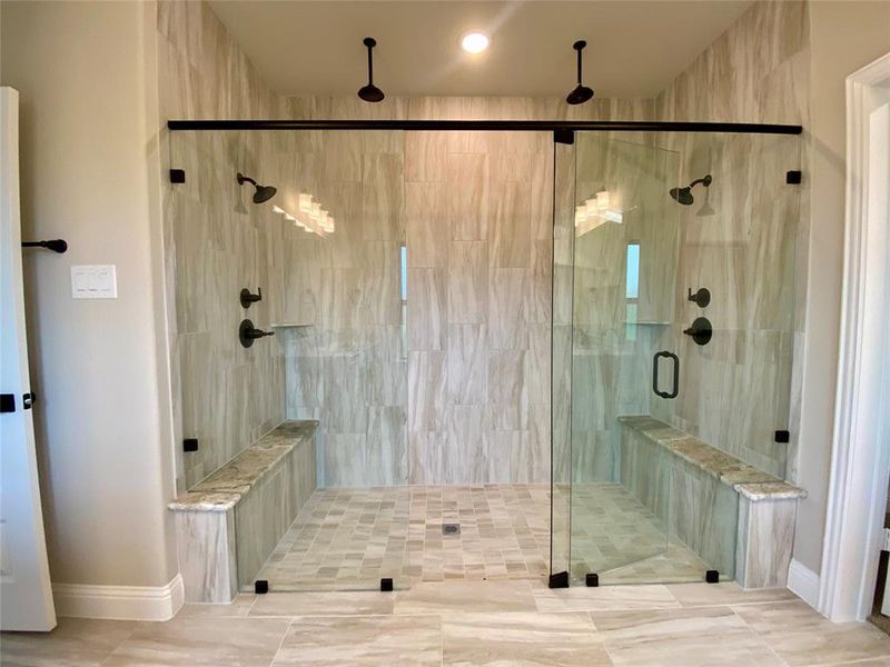 AMAZING extended master shower has frameless glass, tile pan, 2 benches, 2 shower heads, and 2 rain heads!