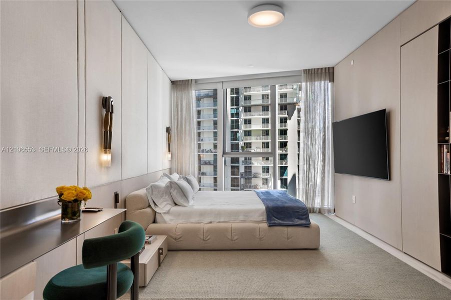 Floor-to-ceiling windows, custom light-toned wood paneling, wall-mounted light fixtures, flush-mount overhead lighting, and built-in shelving