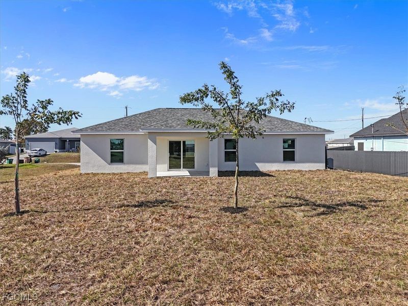 Rear view of property with stucco siding and a shingled roof