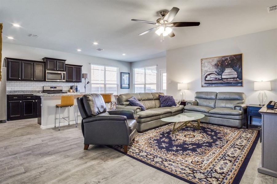 Living room with recessed lighting, visible vents, a ceiling fan, and light wood finished floors