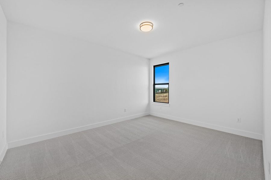 Spare room featuring light carpet and baseboards