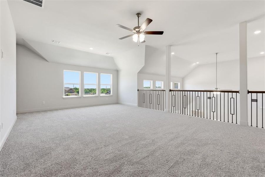 Carpeted spare room with ceiling fan, vaulted ceiling, and recessed lighting