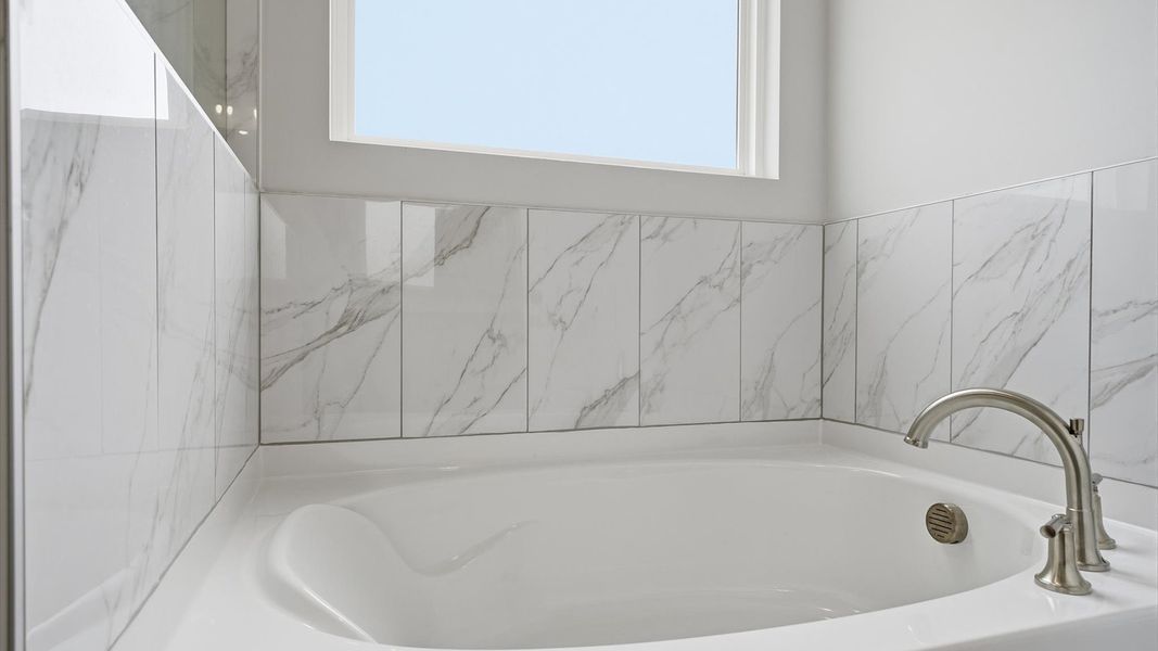 Superior en-suite primary bathroom with natural light and a large soaking tub—crafted with high standards in mind Superior en-suite primary bathroom with natural light and a large soaking tub—crafted with high standards in mind