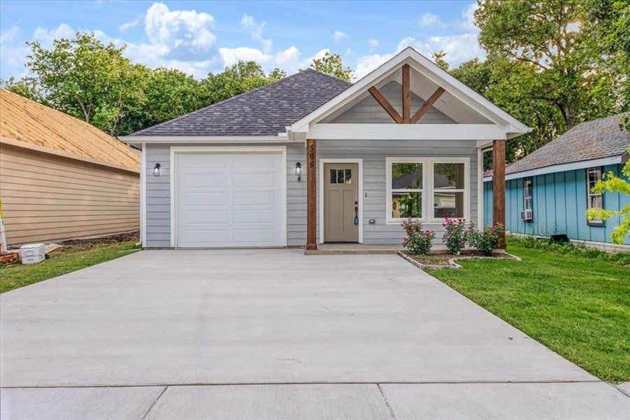 View of front of house with a front lawn and a garage