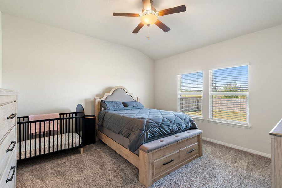 Spacious primary bedroom with vaulted ceiling, large windows, and soft carpet, offering a peaceful retreat. Spacious primary bedroom with vaulted ceiling, large windows, and soft carpet, offering a peaceful retreat.