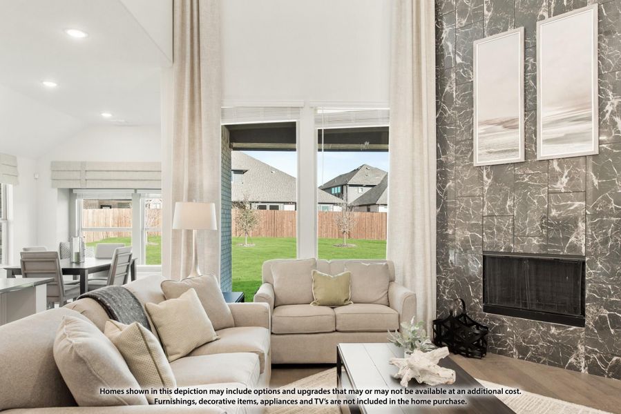 Living room with high ceilings, marble fireplace wall, neutral sofas, and large windows overlooking a backyard Living room with high ceilings, marble fireplace wall, neutral sofas, and large windows overlooking a backyard