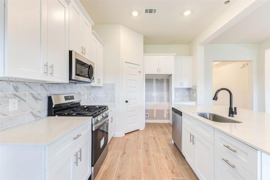 Gas range and oven, microwave, dishwasher, disposal, and stylish cabinetry with soft closed drawers designed for both beauty and function.