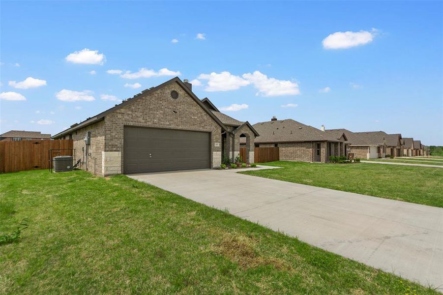 Brick exterior with stone accents, a gabled roof, and an attached two-car garage
