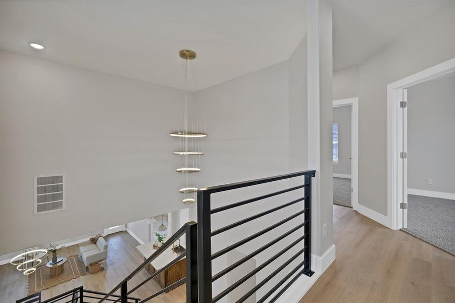 Corridor featuring an upstairs landing, wood finished floors, and baseboards Corridor featuring an upstairs landing, wood finished floors, and baseboards