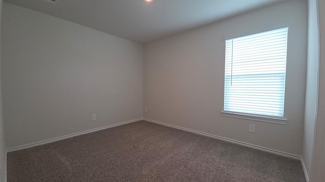 Carpeted interior room with neutral-toned walls, a single window with horizontal blinds, and white baseboards Carpeted interior room with neutral-toned walls, a single window with horizontal blinds, and white baseboards
