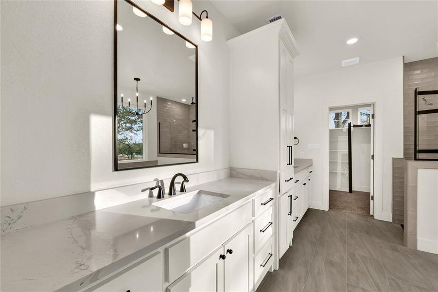 Bathroom with vanity, a stall shower, plenty of natural light, and a spacious closet Bathroom with vanity, a stall shower, plenty of natural light, and a spacious closet