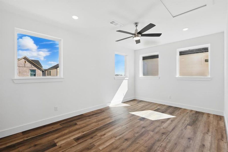 Spare room featuring plenty of natural light, dark wood finished floors, visible vents, and baseboards