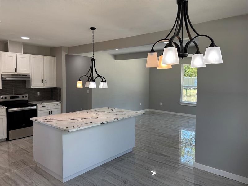 Kitchen with stainless steel range with electric stovetop, decorative backsplash, pendant lighting, white cabinetry, and recessed lighting Kitchen with stainless steel range with electric stovetop, decorative backsplash, pendant lighting, white cabinetry, and recessed lighting
