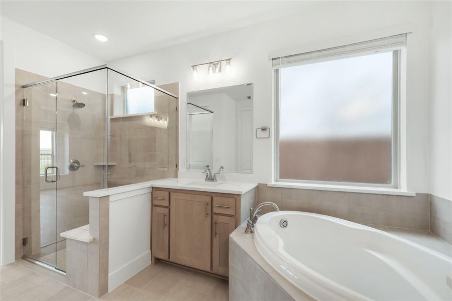 Bathroom with glass walk-in shower, soaking tub, and single vanity with wood cabinets