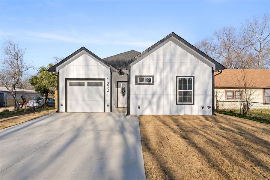 View of front of house featuring concrete driveway, board and batten siding, and a garage