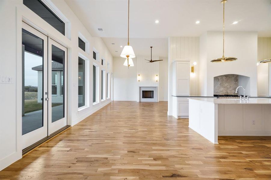 Kitchen with white cabinetry, ceiling fan, hanging light fixtures, and light hardwood / wood-style floors