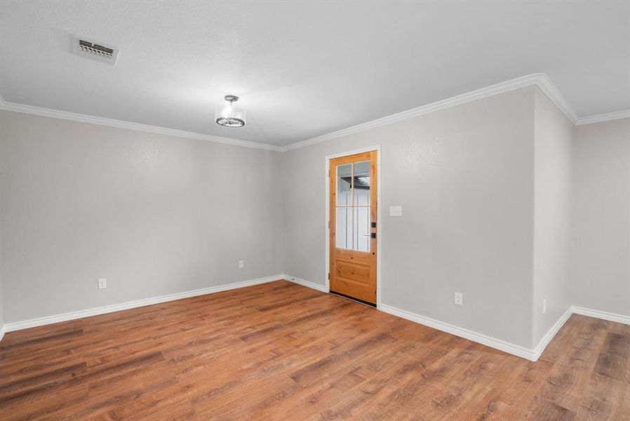 Empty room with hardwood / wood-style flooring and crown molding Empty room with hardwood / wood-style flooring and crown molding