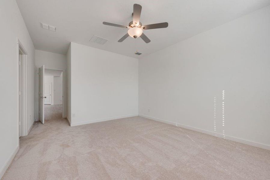 Spare room with light colored carpet and a ceiling fan Spare room with light colored carpet and a ceiling fan