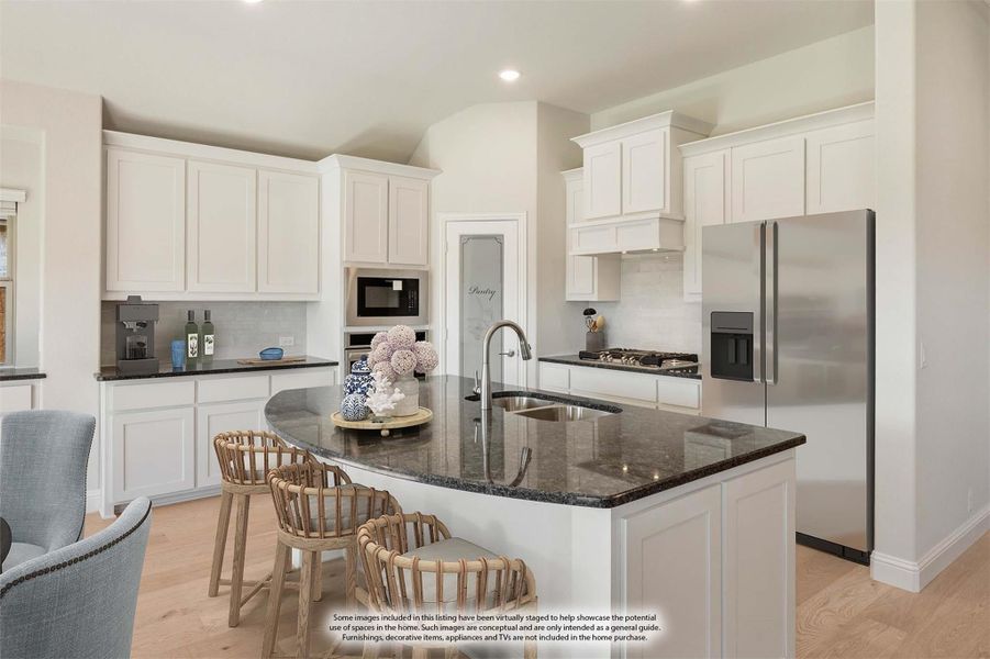 Kitchen with white cabinets, dark granite island with seating, and stainless steel appliances Kitchen with white cabinets, dark granite island with seating, and stainless steel appliances