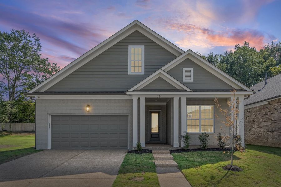 View of front of property with driveway, a garage, and brick siding