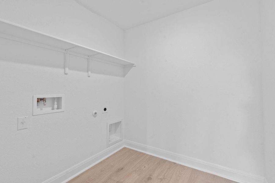 Laundry area with light wood-style flooring, gas dryer hookup, hookup for an electric dryer, and washer hookup Laundry area with light wood-style flooring, gas dryer hookup, hookup for an electric dryer, and washer hookup