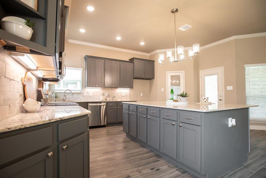 Kitchen featuring gray cabinets, a chandelier, ornamental molding, dark wood-type flooring, and a center island Kitchen featuring gray cabinets, a chandelier, ornamental molding, dark wood-type flooring, and a center island
