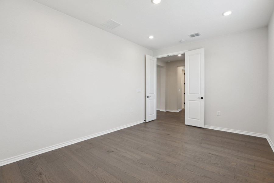 Empty room featuring recessed lighting and dark wood-type flooring