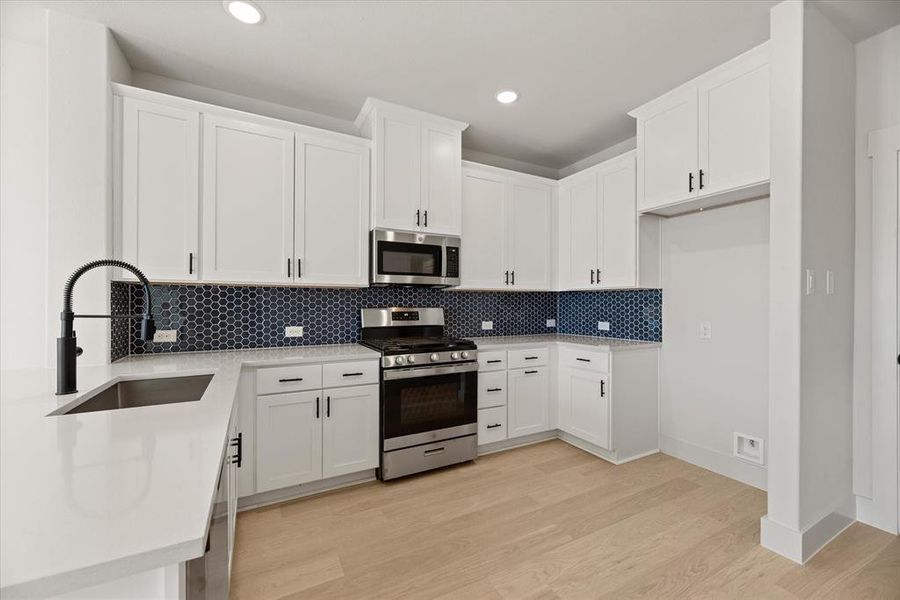 Crisp clean whites paired with a striking backsplash and modern stainless steel create the kitchen of your dreams!