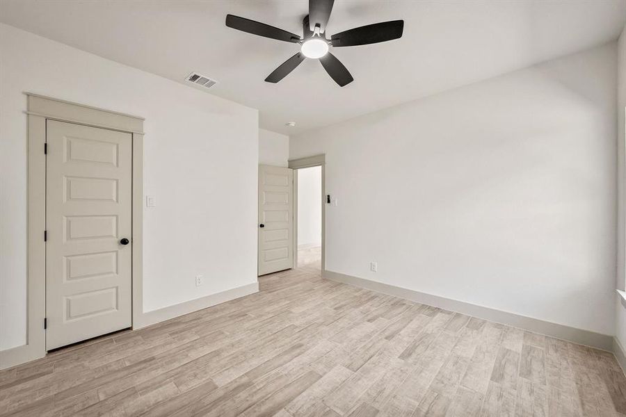 Unfurnished bedroom with a ceiling fan and light wood-type flooring