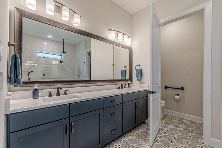Full bathroom featuring double vanity and a stall shower