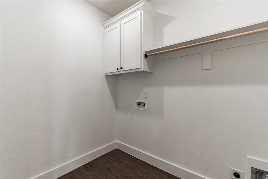 Clothes washing area with cabinets, washer hookup, dark hardwood / wood-style flooring, and electric dryer hookup