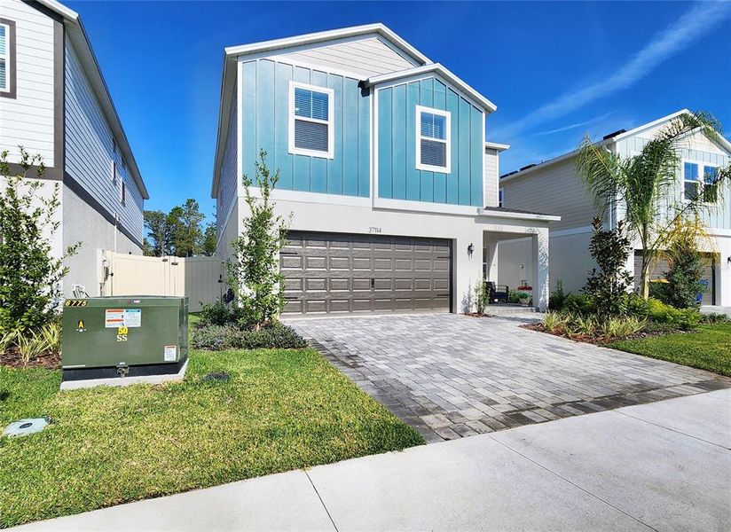 Front exterior of a new home in Two Rivers, Zephyrhills, FL, highlighting curb appeal (Image 26). Front exterior of a new home in Two Rivers, Zephyrhills, FL, highlighting curb appeal (Image 26).