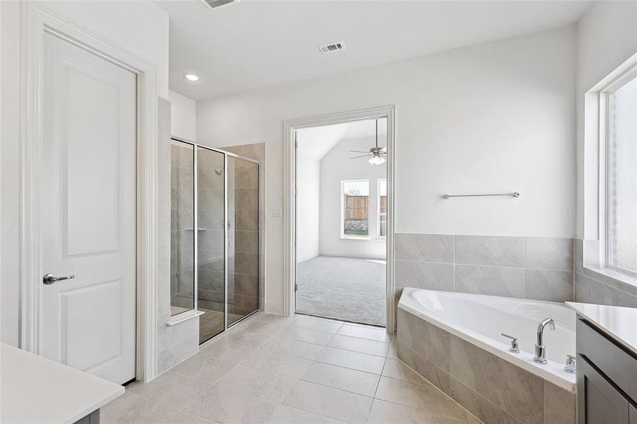 Full bathroom featuring vanity, a stall shower, a garden tub, light tile patterned flooring, and recessed lighting