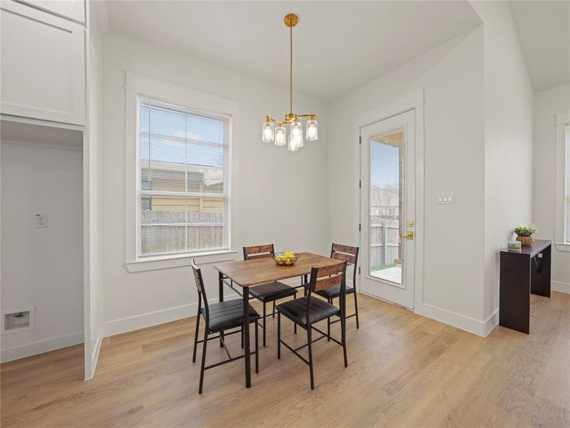 Dining space with light wood-style flooring and hanging lights